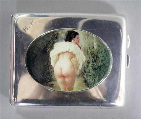 A George V silver cigarette case with later enamelled oval plaque of a lady on a windy day, by John Rose, Birmingham, 1928, 10.1cm.